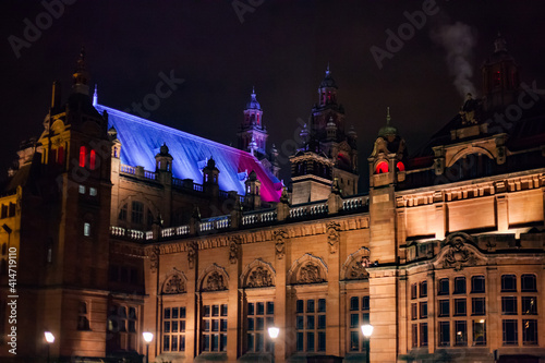 Glasgow, Scotland in fall. Kelvingrove Art Gallery and Museum at night. Color illumination of building. Black night sky. photo