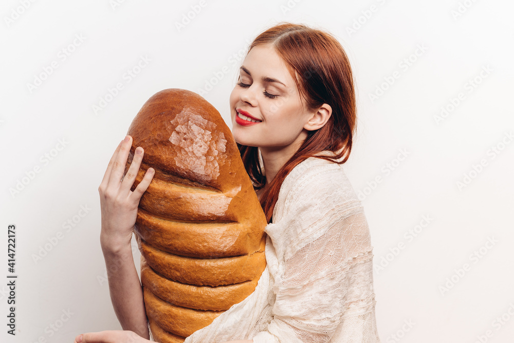 woman holding a large loaf and bright makeup in her hands Light clothing model