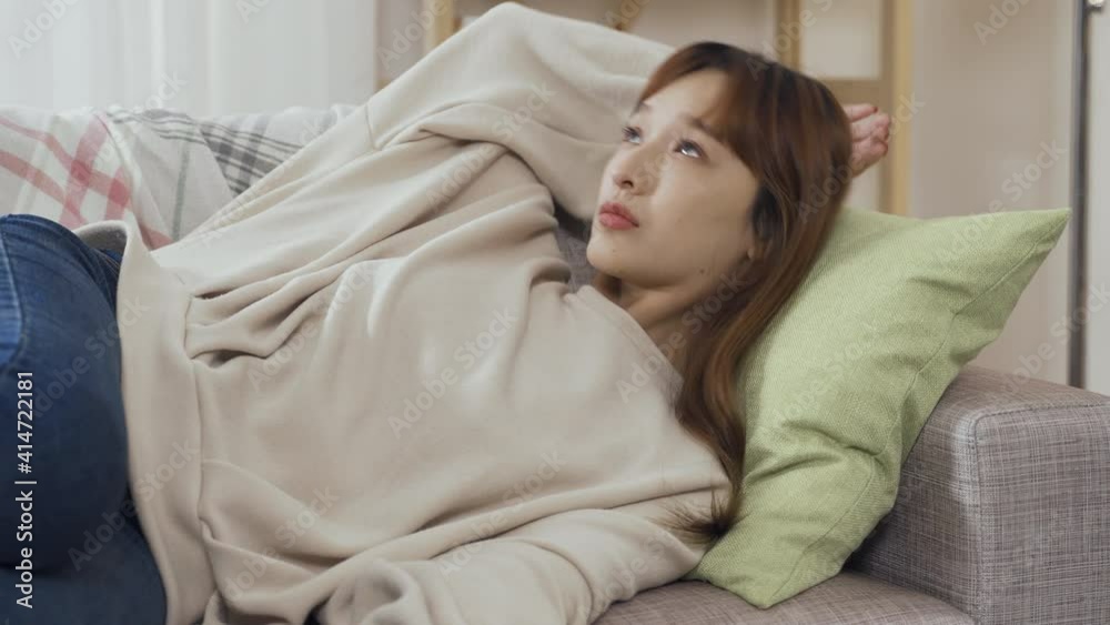 asian lady lying on couch switching off phone screen, hand behind head, staring ceiling feels vexed. korean female between jobs turning off mobile is worried not getting message or call for interview