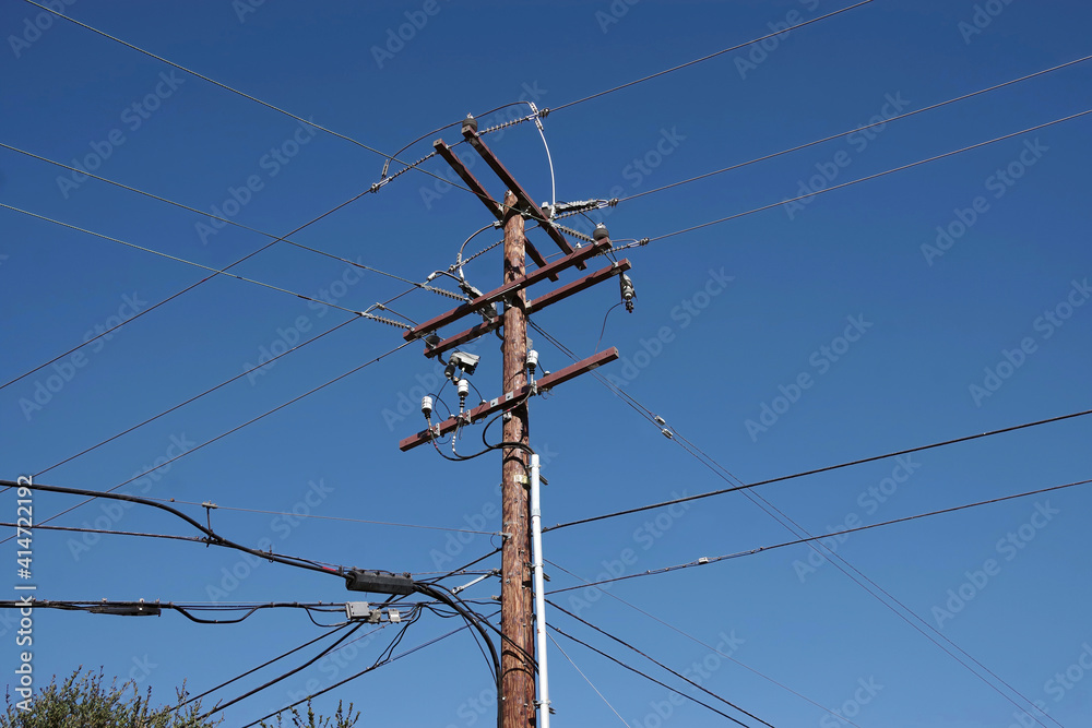 Low angle view of an electricity distribution pylon and power lines under blue sky Low angle view of an electricity distribution pylon and power lines under blue sky