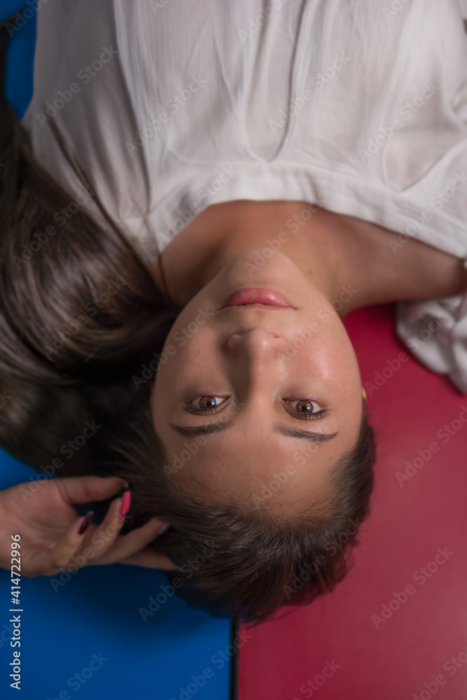 zenith view of beautiful smiling Hispanic woman with long black hair staring at the camera with red and blue two-color background zenith view of beautiful smiling Hispanic woman with long black hair staring at the camera with red and blue two-color background