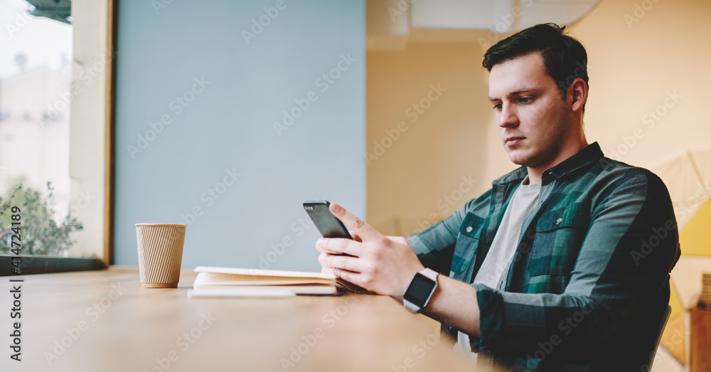 Serious man surfing internet on smartphone in cafe Serious man surfing internet on smartphone in cafe