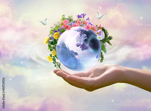 Earth Day or World Environment Day concept. Save our Planet, restore and protect green nature, sustainable lifestyle and Climate literacy theme. Blooming rose, daisy flowers on globe in hand, 22 april