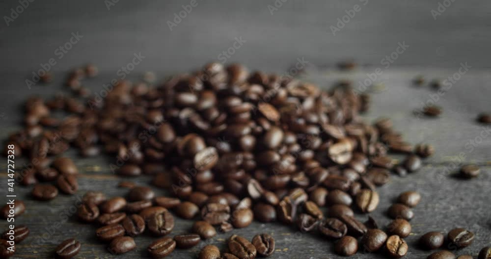 Roasted arabica coffee beans scattered on a wooden table. Fresh coffee beans. Espresso, americano, doppio, cappuccino, latte. Robusta. Selective focus. Roasted arabica coffee beans scattered on a wooden table. Fresh coffee beans. Espresso, americano, doppio, cappuccino, latte. Robusta. Selective focus.