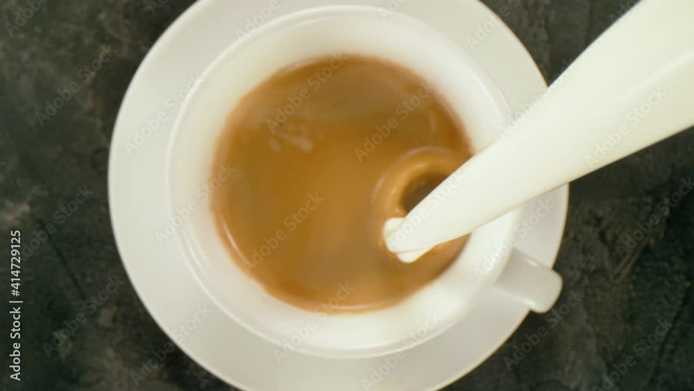 Super slow motion of pouring milk into cup of coffee with camera follow. Filmed on high speed cinema camera, 1000 fps. Super slow motion of pouring milk into cup of coffee with camera follow. Filmed on high speed cinema camera, 1000 fps.