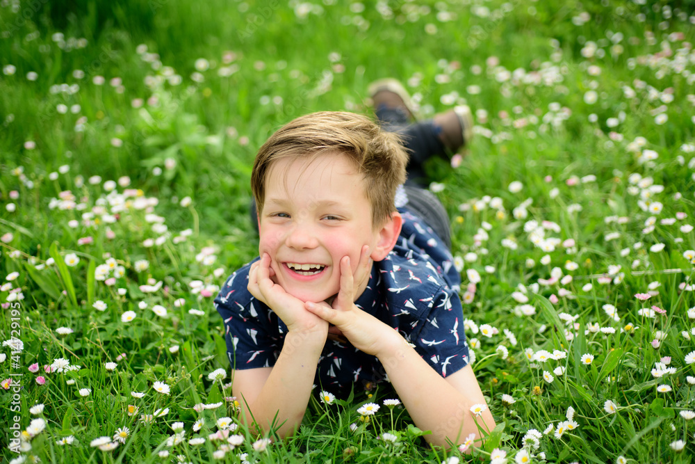 Smiling boy lying on carefree flower field. Cute kid child enjoying on field and dreaming. Smiling boy lying on carefree flower field. Cute kid child enjoying on field and dreaming.