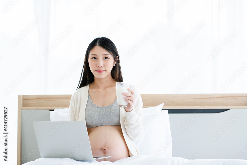 Pregnant Asian mother drink milk that is healthy for the body and the unborn child. Use a laptop to find health care. Online shopping for kid. Bedroom are clean and safe. Pregnant Asian mother drink milk that is healthy for the body and the unborn child. Use a laptop to find health care. Online shopping for kid. Bedroom are clean and safe.