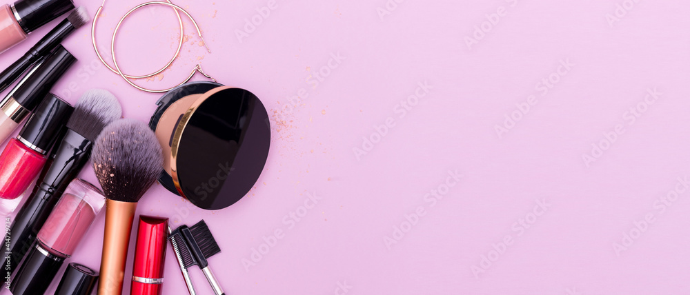 Banner. Make up the essentials. A set of professional makeup brushes and  cosmetics on a pink