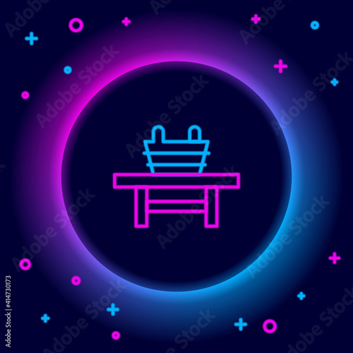 Glowing neon line Sauna bench with bucket icon isolated on black background. Colorful outline concept. Vector.