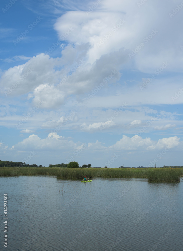 hombre remando en kayak laguna cielo despejado