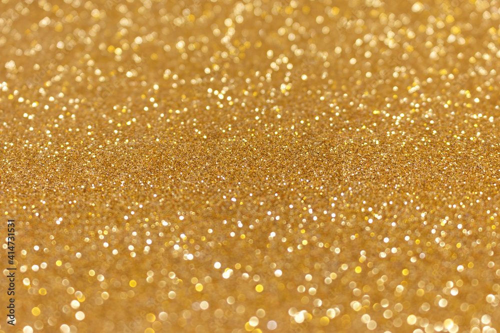 Golden glitter texture background. Shiny defocused festive backdrop.