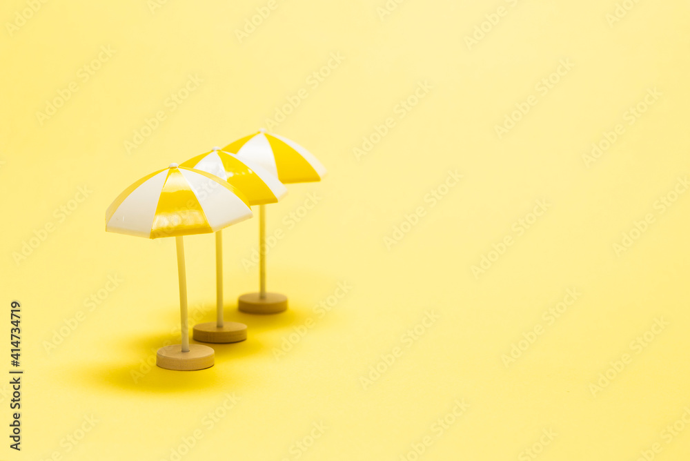 Sun lounger and yellow umbrella on a yellow background.