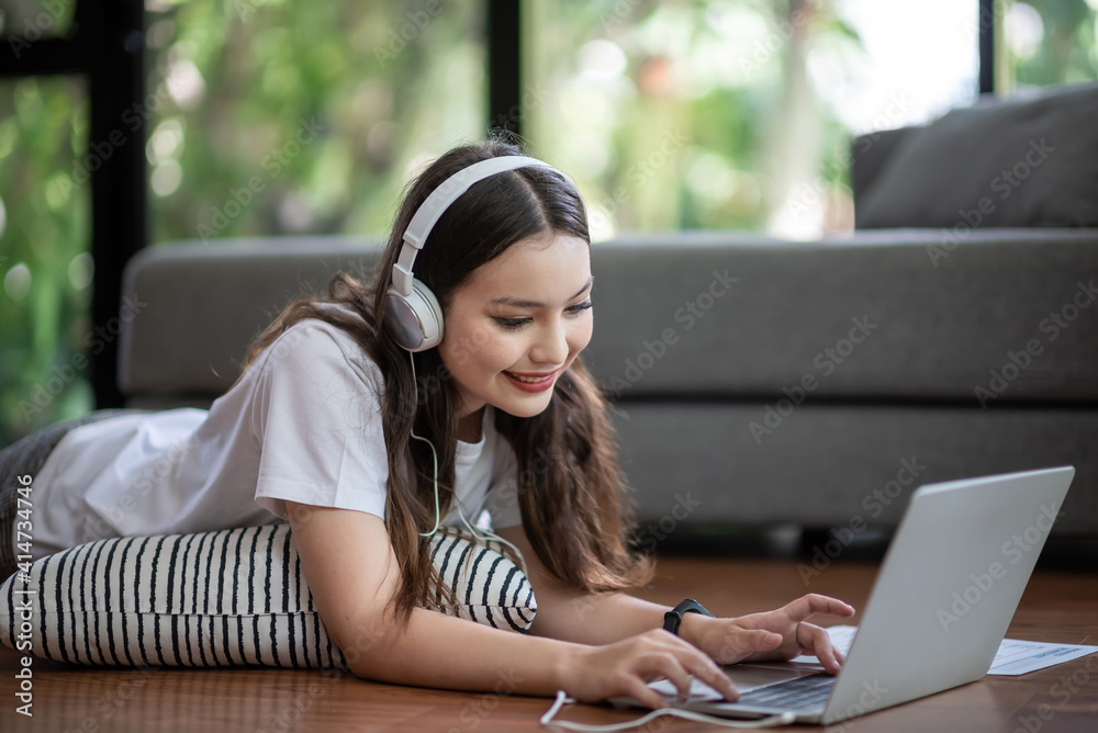 Beautiful smiling woman With a headset, relax by using the laptop at home.