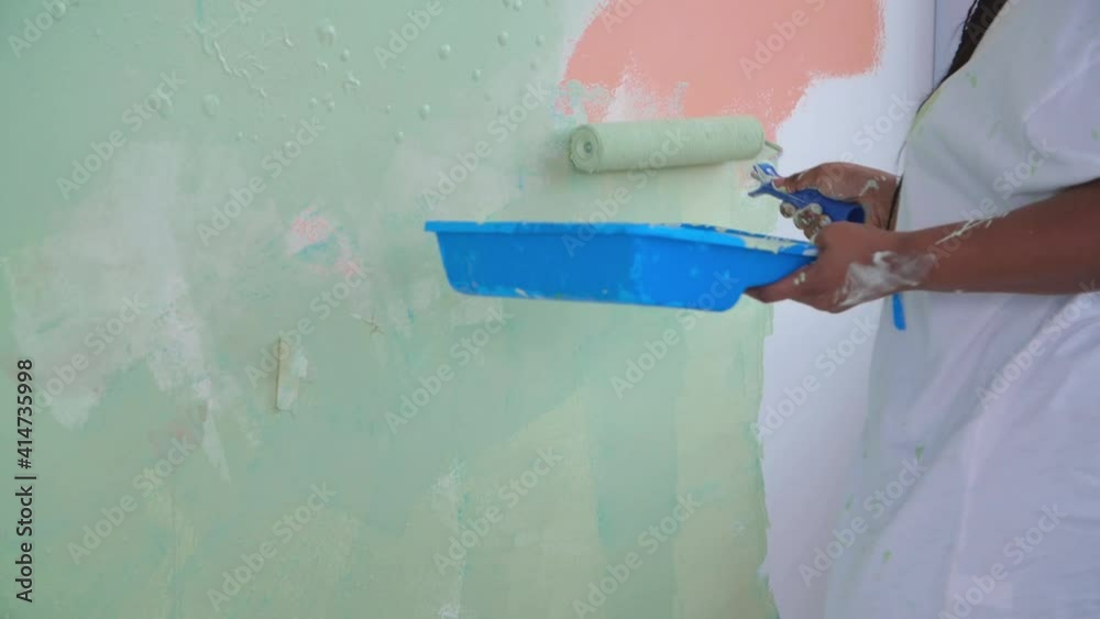 custom made wallpaper toronto digitalFlat renovation concept. Smiling African American woman redecorating her house holding a paint roller covered in orange and green paint