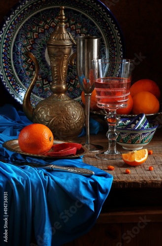 Oriental still life with red wine and oranges on wooden background photo