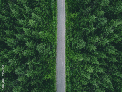 Aerial view of country road through green summer forest in Finland