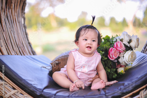 Asian baby girl with happiness, Portrait 8 month infant child toddler sitting in pink dress and happy smiling.
