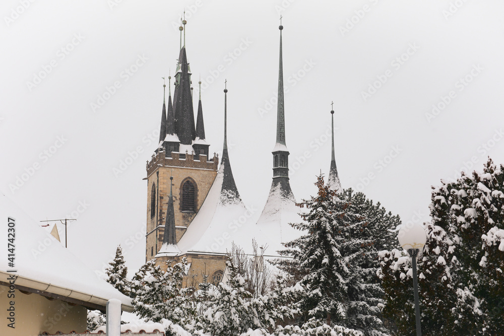 Gothic Church of St Nicholas in Louny. Winter season in Louny town, Czech Republic. Snow on roofs of church. 