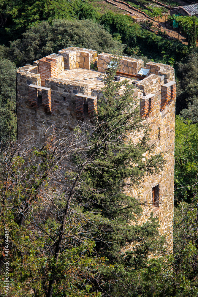 Looking down on a renellated square tower behind the Narikala Fortress or castle on the hill above Tbilisi Georgia.j Looking down on a renellated square tower behind the Narikala Fortress or castle on the hill above Tbilisi Georgia.j