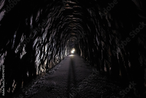 Looking through a 175 year old tunnel  with flashlights shining midway through