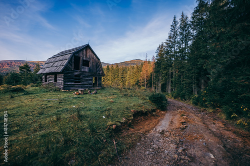 A house that has a sign on a dirt track