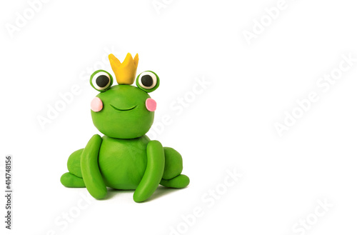 Cute plasticine frog in a crown on a white background