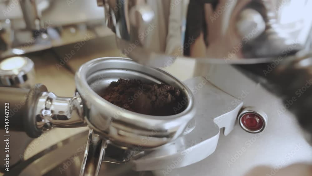 Close-up barista was taking a powder of roasted coffee beans that had been finely ground from the machine to brew them for the customers. Close-up barista was taking a powder of roasted coffee beans that had been finely ground from the machine to brew them for the customers.