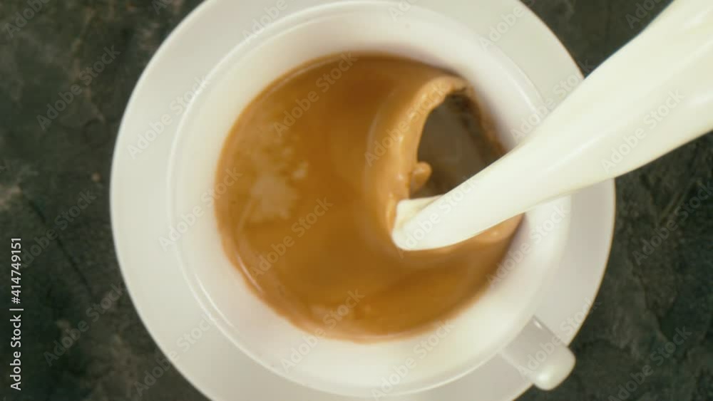 Super slow motion of pouring milk into cup of coffee with camera follow. Filmed on high speed cinema camera, 1000 fps. Super slow motion of pouring milk into cup of coffee with camera follow. Filmed on high speed cinema camera, 1000 fps.