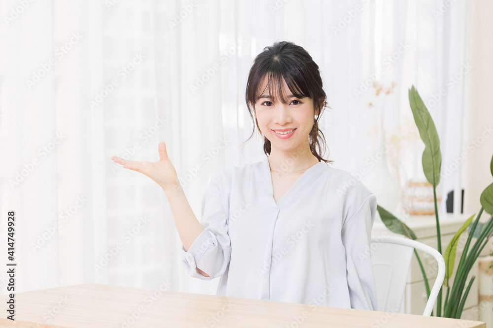 案内のジェスチャーをする若い女性 案内のジェスチャーをする若い女性