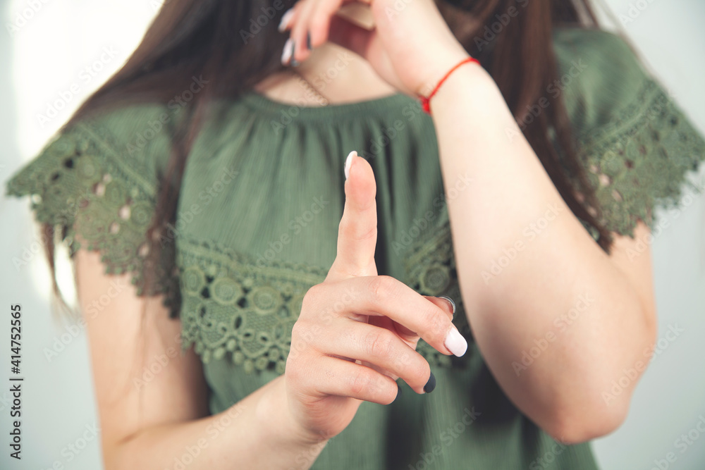 Beautiful young woman raising her finger in a warning gesture. Warning concept