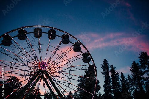 Bild auf Leinwand Ferris Wheel and Lights with Twilight Colorful Clouds at Country Fair
