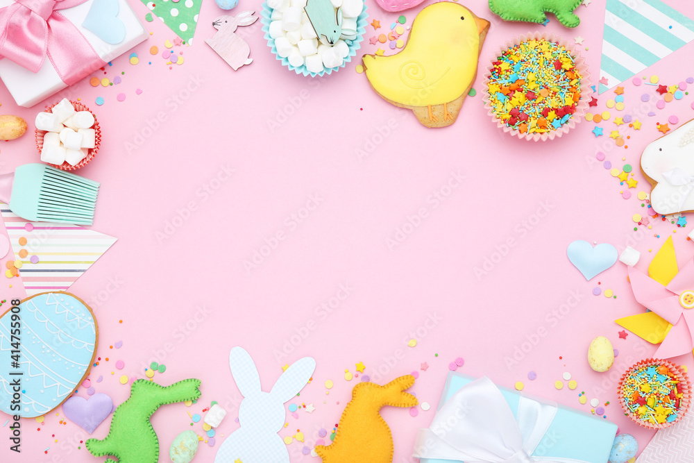 Easter gingerbread cookies with gift boxes, fabric rabbits and sprinkles on pink background