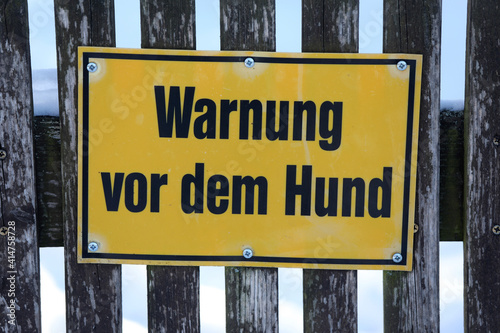 Gelbes Metall Schild "Warnung vor dem Hund" vor Tür Eingang.
