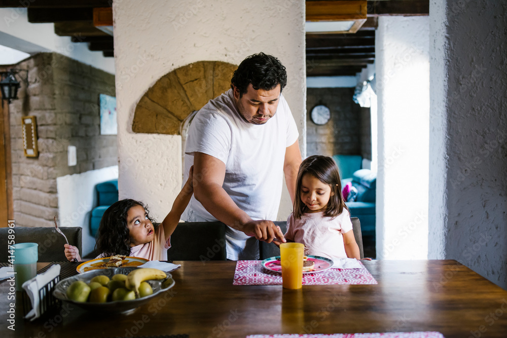 Fototapeta premium hispanic father having breakfast with his mexican daughters in dining room at home in mexico city