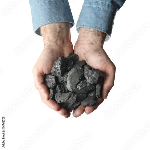 Man holding coal in hands on white background, top view