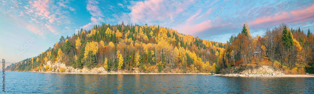 Panoramic landscape, high river bank with autumn forest, bright colors of autumn, bright morning clouds, golden foliage.