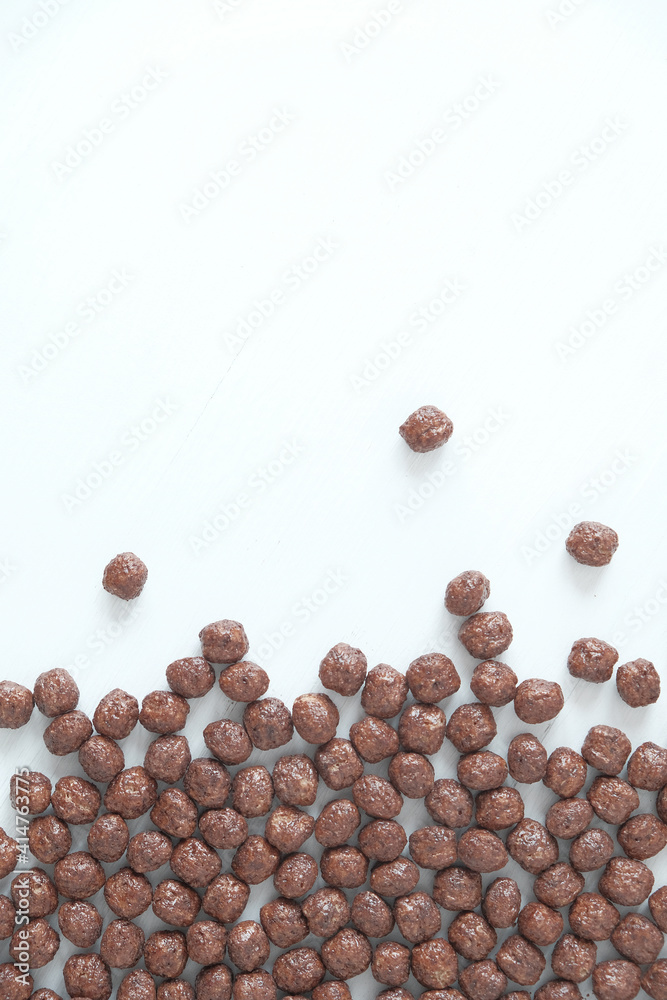 Chocolate corn balls scattered on a white background. Top view. Copy, empty space for text Chocolate corn balls scattered on a white background. Top view. Copy, empty space for text
