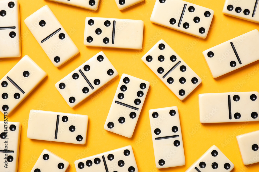 Classic domino tiles on yellow background, flat lay Classic domino tiles on yellow background, flat lay