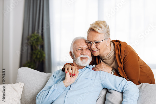 Happy senior couple relaxing together on a sofa at home