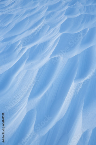 Fototapeta Naklejka Na Ścianę i Meble -  Snow texture. Wind sculpted patterns on snow surface. Wind in the tundra and in the mountains on the surface of the snow sculpts patterns and ridges (sastrugi). Arctic, Polar region. Winter background
