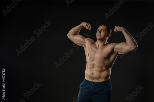 Man's biceps shows bare torso Young male confident fashion, casual bodybuilder. Beautiful trendy, dumbbell smile background black bodybuilder