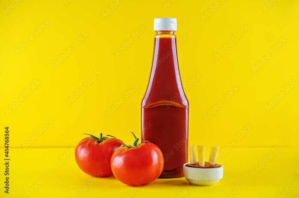 Tomato ketchup with French fries and fresh tomatoes on a yellow background Tomato ketchup with French fries and fresh tomatoes on a yellow background