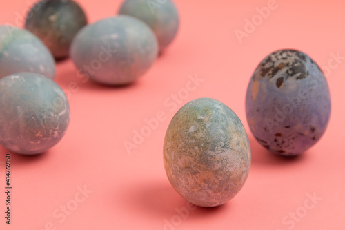 Colorful Easter eggs on a light pink paper background