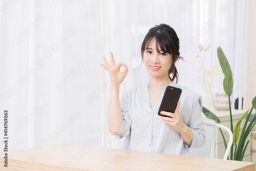 部屋でスマホを使う若い女性 部屋でスマホを使う若い女性