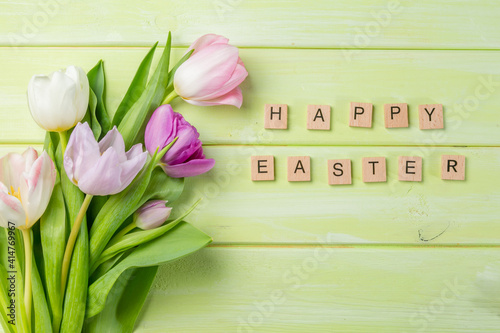 Easter concept - cookies with flowers on green wood background, copy space