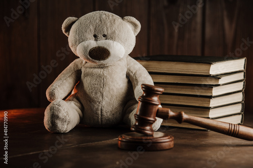 Divorce and alimony concept. Wooden gavel and teddy bear as symbol of child on a desk.