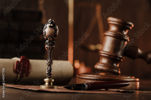 Vintage stamp and judge gavel close-up on a wooden desk.