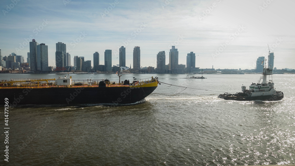 Naklejka premium A barge is being towed on the East River, New York City.