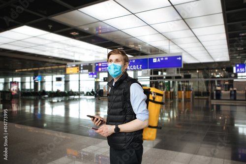 Passenger travel for work. Man wearing face mask Hand holding smart phone. COVID-19 app for test results before airplane. Covid pass for traveling. PCR test for flight at the airport terminal.
