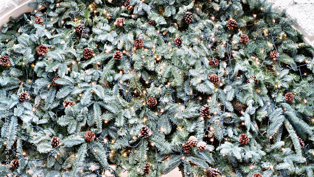 Stylish christmas street decorations, green fir branches with red bows on christmas trees